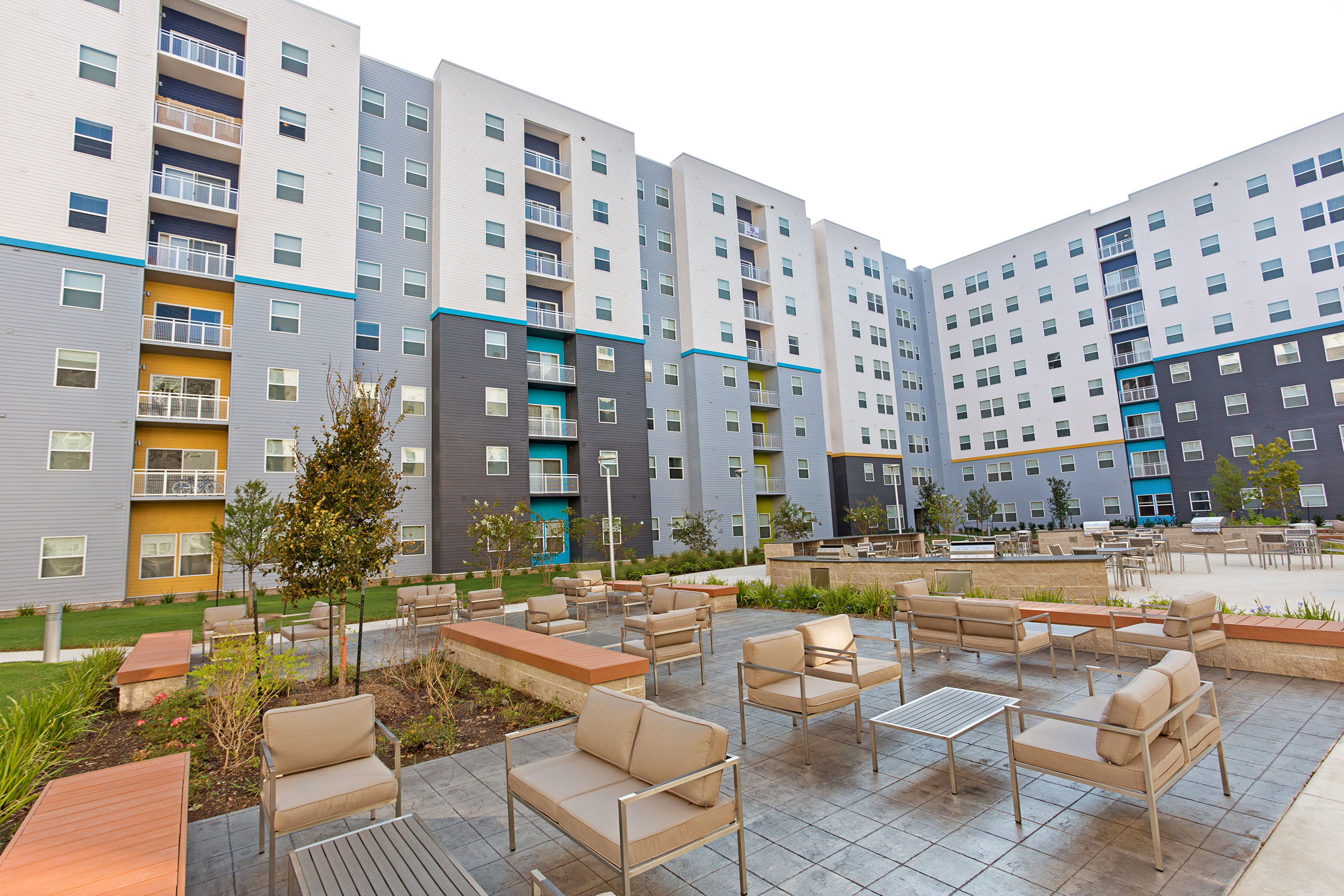 Courtyard outside of a multi-story wraparound building with crisp, clean looking paint.